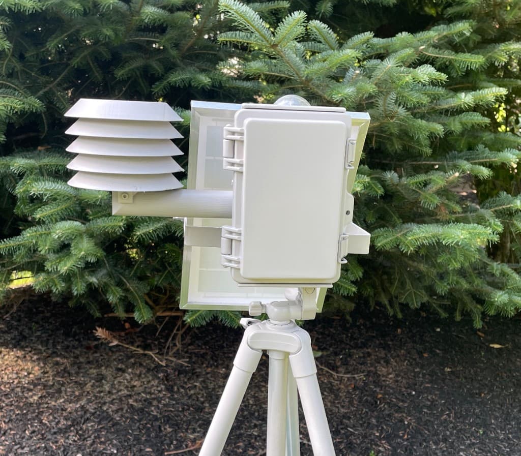 Sample Omnisond station enclosure, radiation shield, and solar panel on a field tripod